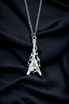 Calling all music lovers! Strike a chord with our Fire Electro Guitar Necklace. This one-of-a-kind piece is not just a necklace, but a statement of your passion and love for music. Perfect for both men and women, it's a versatile accessory that can add a rock-and-roll edge to any outfit. The pendant, a silver-plated fire electro guitar, is meticulously crafted with an eye for detail. It's a mini masterpiece that captures the spirit of music and the thrill of live performances. The pendant comes Silver Music-themed Metal Necklace, Silver Music-themed Metal Jewelry, Music-themed Silver Metal Jewelry, Silver Metal Necklace For Concert, Nickel-free Silver Jewelry For Concerts, Silver Rock Jewelry For Concerts, Silver Rock Style Jewelry For Concerts, Nickel-free Silver Music-themed Necklaces, Adjustable Chain Metal Necklace For Concerts