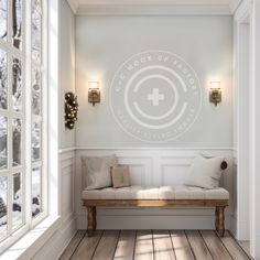 a room with white walls and wood flooring has a bench in front of the window