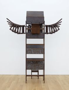 a stack of children's school desks with wings protruding from the sides, like a totem pole Pencil Carving, World Clock, Victorian Wallpaper, Deer Hide, Bear Rug, Tooled Leather Bag, Viewing Room, Downtown Manhattan