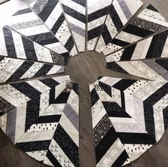 a black and white quilt on the floor with several pieces cut out to look like hexagons