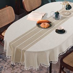 a table with a plate of food on it next to two cups and saucers