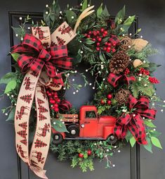 a christmas wreath with a red truck and pine cones