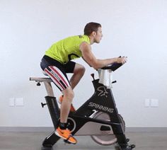 a man is riding an exercise bike on the floor in front of a white wall