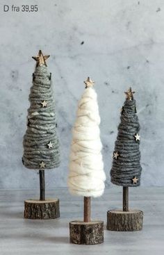 three small christmas trees with white and grey yarn