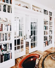 a living room filled with lots of books and furniture