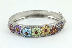 This is Vintage Floral Multi- Stone Bangle Bracelet 925 Sterling BR 1941 Condition: Vintage Metal:  925 Sterling Silver Weight: 36 grams Bracelet Size: 6.5 in Images you see are actual pictures of jewelry you will receive Every purchase comes thoughtfully packaged and ships within 1 business day New York State buyer will be charged sales tax Feel free to contact us with any questions. We are open Mon-Fri 9-5 EST We appreciate your business Multicolor Bangle Bracelets For Anniversary, Multicolor Sterling Silver Bracelet For Anniversary, Sterling Silver Multicolor Bracelets For Anniversary, Multicolor Sterling Silver Anniversary Bracelet, Multicolor Fine Jewelry Bracelet For Wedding, Fine Jewelry Multicolor Wedding Bracelet, Multicolor Round Sterling Silver Bracelet, Formal Multicolor Sterling Silver Bracelets, White Gold Multi-stone Bracelets As Gift