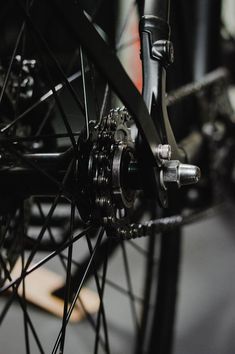 the front wheel of a bicycle with spokes and gears on it's side