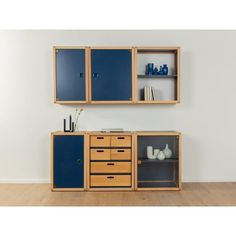 a blue cabinet with drawers and shelves next to a white wall