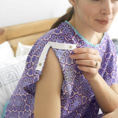 a woman in a purple dress is holding a piece of paper that has been taped to her chest