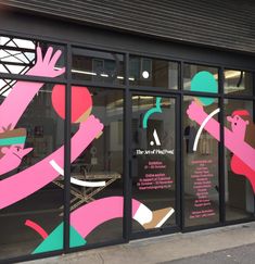 the front window of a store with pink and green designs on it