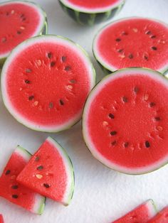 slices of watermelon are arranged on a white surface