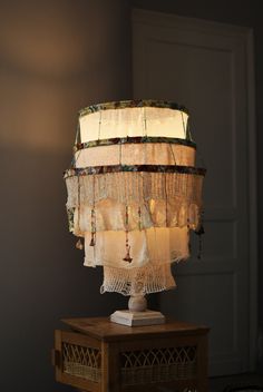 a lamp that is sitting on top of a wooden table next to a wall and door