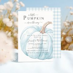 a card with a blue pumpkin on it next to white flowers and cotton floss