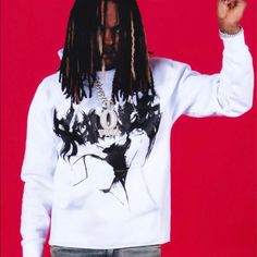 a man with dreadlocks is holding something up to his face while standing against a red background