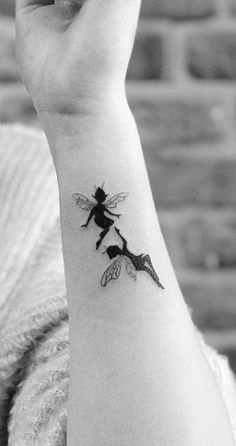 a black and white photo of a woman's wrist tattoo