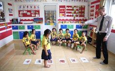 a man standing in front of a classroom full of children