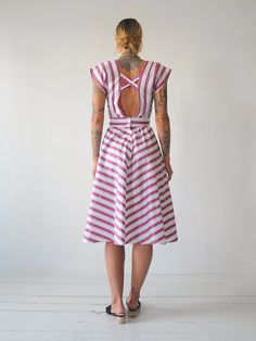 "Vintage 80's chevron striped sundress. Adjustable tie at waist. Open back with buttons down lower back. Full skirt. Lightweight cotton material. - - M E A S U R E M E N T S - - Fits like: xs/small Bust: 17\" Waist: 13\"-adjustable smaller Length: 44\" Hips: open Shoulder: 14.5\" Fabric: cotton In excellent condition - no flaws to note. ● Model is 5'7\" / bust: 34\" / waist: 25\" / hips: 37\"" Striped Cotton Sundress For The Beach, Striped Fitted Midi Sundress, Cotton Summer Dress With Vertical Stripes, Striped Fitted Sundress For Summer, Fitted Striped Sundress For Summer, Cotton Dress With Vertical Stripes For Day Out, Pink Vertical Stripe Summer Dress, Pink Vertical Striped Summer Dress, Striped Summer Daywear Dress