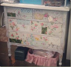 an old dresser with flowers painted on the top and drawers, is shown in this image