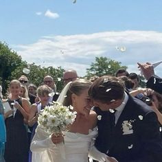 a bride and groom are walking through confetti thrown in the air