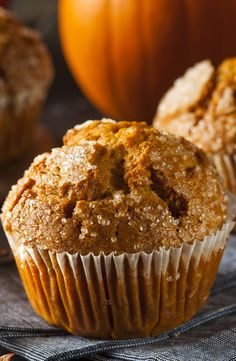 a muffin sitting on top of a table next to some pumpkins and other food