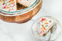 a piece of cake on a plate with a fork next to it and a serving dish