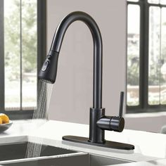 a kitchen faucet with water running from it's spout and fruit on the counter