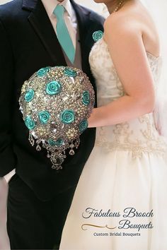 the bride and groom are dressed in black suits with blue flowers on their bouquets