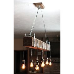 a light fixture with five bulbs hanging from it's sides and some lights on the ceiling