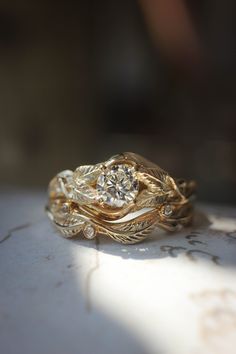 two gold rings with diamonds sitting on top of a white tablecloth covered countertop