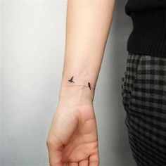 a small bird tattoo on the wrist