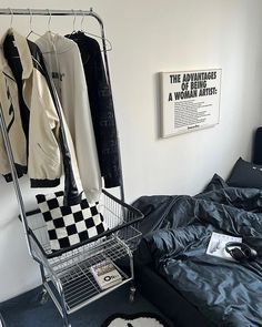 a bedroom with an ironing board on the wall and clothes hanging in a wire basket