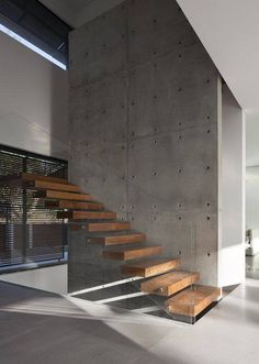 the stairs are made of metal and wood, leading up to the second floor in this modern house