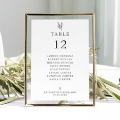 the table numbers are displayed in front of some greenery and candles on a white table cloth