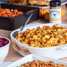 a casserole dish filled with stuffing next to other dishes and condiments