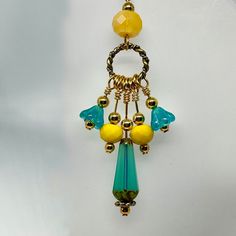 a yellow and blue beaded necklace hanging from a hook