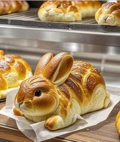 bread shaped like a bunny sitting on top of a table next to other buns