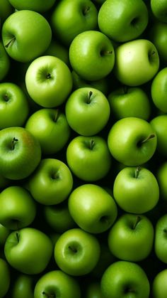 many green apples are stacked up together