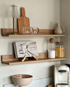 two wooden shelves with various items on them and a coffee maker in the corner next to it