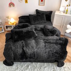 the bed is made with black fur and pillows