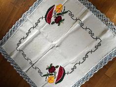 an embroidered tablecloth with roses on it