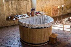 a large wooden tub sitting on top of a brick floor