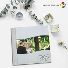 a wedding album with an image of the bride and groom on it, surrounded by greenery