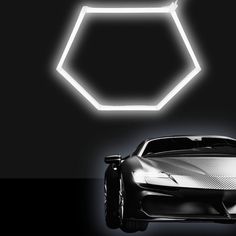 a sports car is shown in front of a hexagonal light fixture with the shape of a honeycomb