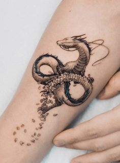 a woman's arm with a dragon tattoo on it