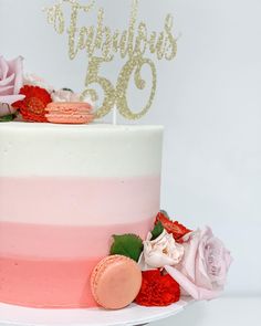 a pink and white cake with flowers on top