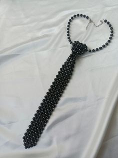 "Black Pearl Neck Tie Faux Pearl Necklace, unique statement for you" Step into sophistication with our exquisite Black Pearl Tie adorned with shimmering silver beads. Crafted with meticulous attention to detail, each tie is a testament to timeless elegance and impeccable craftsmanship. **Perfect for special occasions or adding a touch of glamour to everyday attire, our Black Pearl Tie is sure to turn heads and make a statement wherever you go. #Embrace the allure of understated luxury and elevat Neck Tie Necklace, Formal Black Beaded Necklace, Elegant Black Beaded Necklaces, Adjustable Black Beaded Necklaces For Evening, Adjustable Black Beaded Necklace For Evening, Elegant Beaded Necklace For Party, Elegant Black Beaded Necklaces For Evening, Adjustable Beaded Necklaces For Formal Occasions, Elegant Black Beaded Necklace For Evening