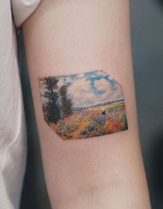 a woman's arm with a small painting on the left side of her arm