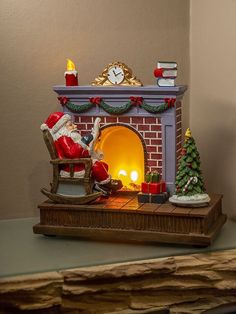 a santa claus figurine sitting in front of a fireplace with a lit candle