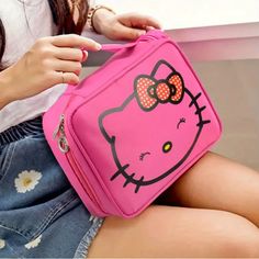 a woman is holding a pink hello kitty bag