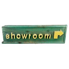 a green sign that says showroom with an arrow pointing to the left and right